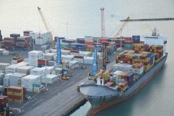 Conteneurs et grues portuaires dans un port commercial.